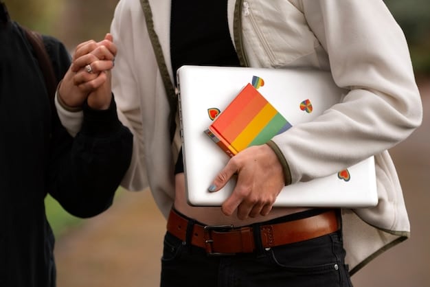 A close-up of a student's hand holding a pamphlet about LGBTQ+ rights on a university desk, with textbooks and a laptop in the background.